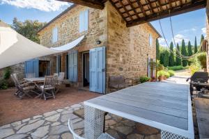 an outdoor patio with a wooden table and chairs at Private Tuscan Villa with Infinity Pool & Views in Vagliagli