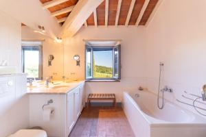 a bathroom with a tub and a toilet and a sink at Private Tuscan Villa with Infinity Pool & Views in Vagliagli +40 photos