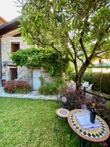 a table and chairs in a yard with a tree at Castello Cottage in Argegno