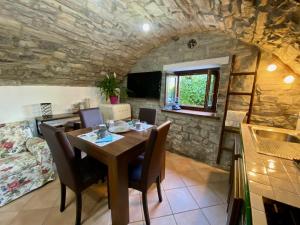 a dining room with a wooden table and chairs at Castello Cottage in Argegno +8 photos