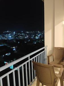 a balcony with a view of a city at night at Mithra Cottages individual Villa in Ooty