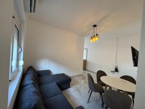 a living room with a blue couch and a table at Apartmani Srdanovic in Tivat