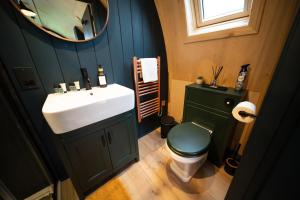 a bathroom with a sink and a toilet and a mirror at Hillend by Wigwam Holidays in Todmorden