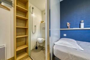 a bathroom with a bed and a shower and a toilet at UNISOTEL Le Havre in Le Havre