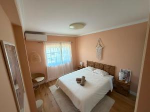 a bedroom with a bed with a cross on it at Capsule Marisol Family Retreat in Corroios