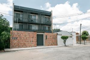an apartment building with a brick wall at El Pocito by Homirent in El Jacal