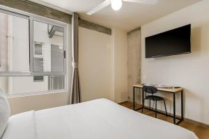 a bedroom with a bed and a desk and a tv at El Pocito by Homirent in El Jacal