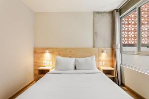 a bedroom with a white bed and a window at El Pocito by Homirent in El Jacal