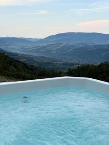 a swimming pool with a view of the mountains at Skalne Wzgórze in Ochotnica Dolna