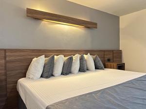 ein Schlafzimmer mit einem Bett mit weißen Laken und Kissen in der Unterkunft Hotel El Sembrador in Guasave + 41 Fotos