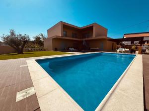 a house with a swimming pool in front of a house at L'École Villa Nature in Abrantes
