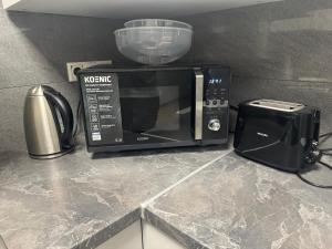a microwave sitting on top of a counter with a toaster and a toaster at Hansa Living 3 Hamburg - Ruhiges Zimmer mit Gemeinschaftsküche in Hamburg