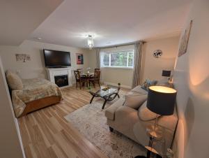 a living room with a couch and a tv at Modern, private & luxurious executive suite in Delta