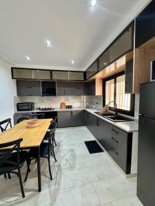 a kitchen with a wooden table and a dining room at Pool House et Rooftop Hammamet in Dar Hamad Jedidi