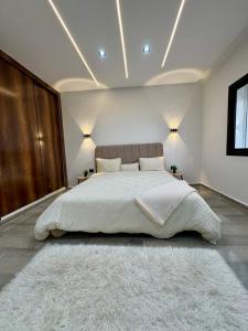 a bedroom with a large bed and a white rug at Pool House et Rooftop Hammamet in Dar Hamad Jedidi