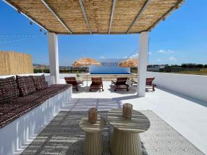 a patio with a couch and tables and umbrellas at Pool House et Rooftop Hammamet in Dar Hamad Jedidi