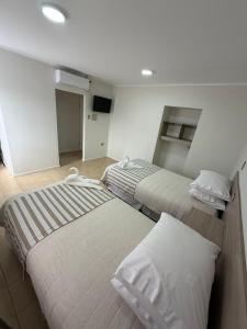 two twin beds in a room with at Hotel Frontera in Antofagasta