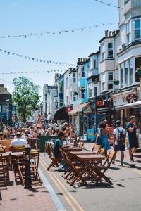 a group of people walking down a city street at Cozy Kingfisher - 2-Bed Bungalow in Brighton near the Beach With Free WiFi & Terrace by Kozmo Properties in Brighton & Hove