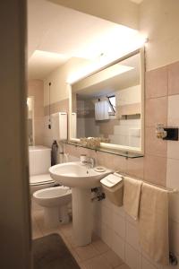 a bathroom with a sink and a toilet and a mirror at B&B Camilla in Rimini