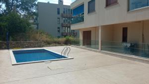 a swimming pool in front of a building at Azzuro - Cozy Studio with Balcony near Beach in Donja Lastva