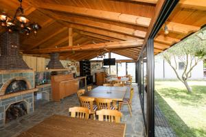 an outdoor kitchen with a table and a fireplace at Guesthouse Micaj ERDEO in Hor