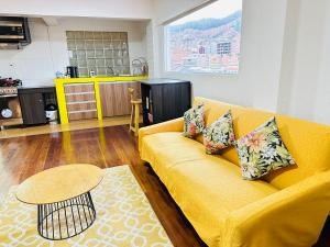 a living room with a yellow couch and a table at Skyline in La Paz