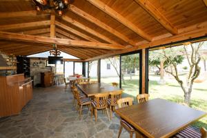 a pavilion with tables and chairs and windows at Guesthouse Micaj ERDEO in Hor