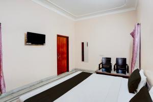 a room with a bed and two chairs and a television at Hotel O Hotel Brijwasi in Lucknow +21 photos