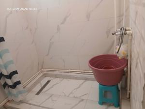 ein Badezimmer mit Toilette und einem Eimer auf dem Boden in der Unterkunft سكيكدة in Skikda