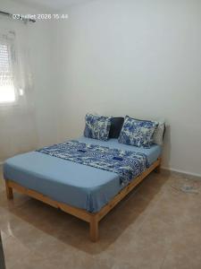 ein Bett mit blauen Laken und Kissen in einem Zimmer in der Unterkunft سكيكدة in Skikda