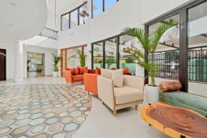 an open living room with orange furniture and windows at Verano Hotel & Spa Arpora Goa in Arpora