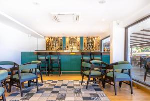 a restaurant with a bar with chairs and tables at Verano Hotel & Spa Arpora Goa in Arpora