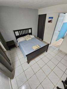 a bedroom with a bed and a tiled floor at Above the Plaza 6 (with A/C) in Rincon