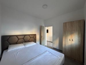 a bedroom with a bed and a wooden cabinet at Apartmani Srdanovic in Tivat +55 photos