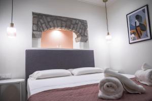 a white bedroom with a bed with a large headboard at Akrolithos apartments 1st floor in Platy