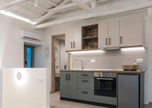 a kitchen with white cabinets and a stove top oven at Akrolithos apartments 1st floor in Platy