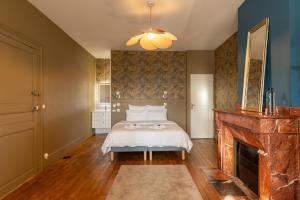 a bedroom with a bed and a fireplace at Casa Miasto - Chambres d'hôtes & Spa in Aspet