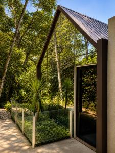 a pivot door to a house with a garden at Chamanica in Coroico