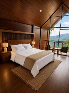 a bedroom with a large bed and a large window at Chamanica in Coroico