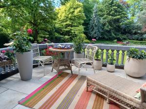 a patio with chairs and a table and potted plants at Le Jardin des Roses Mons & Pairi Daiza proches in Dour +21 photos