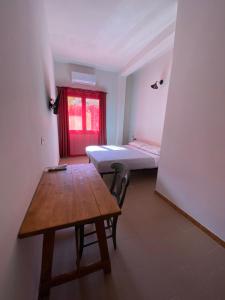 a room with a table and a bed and a desk at Domu hermosa in Villaputzu