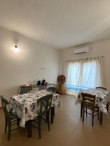 a dining room with two tables and chairs and a window at Domu hermosa in Villaputzu