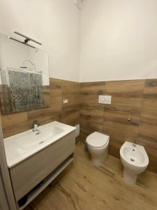 a bathroom with a white sink and a toilet at Domu hermosa in Villaputzu +8 photos