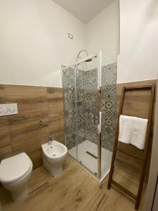 a bathroom with a toilet and a glass shower at Domu hermosa in Villaputzu