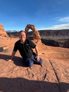 a man sitting on a rock in the desert at Green River Inn Apartments in Green River