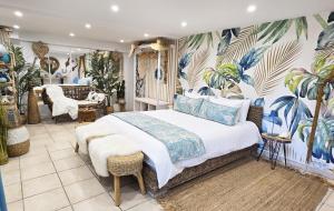 a bedroom with a bed with a tropical wallpaper at Le Nid Bleu in Le Beausset