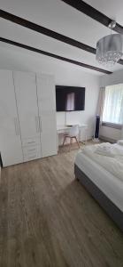 a white bedroom with a bed and a desk at Hotel Surselva in Chur