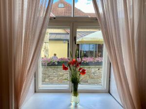 a vase of flowers sitting on a table in front of a window at Kauba 6-5 Apartment in Kuressaare +4 photos
