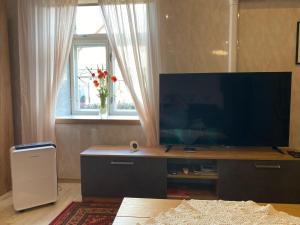a living room with a flat screen tv and a window at Kauba 6-5 Apartment in Kuressaare
