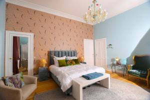 a bedroom with a large bed and a chair at Le Jardin des Roses Mons & Pairi Daiza proches in Dour